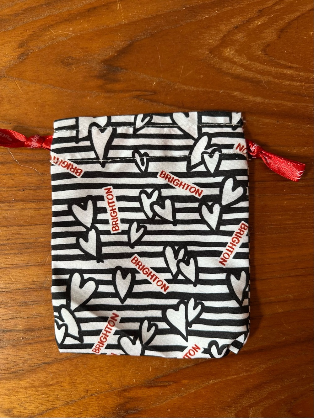Brighton black and white stripe drawstring pouch with red hearts.